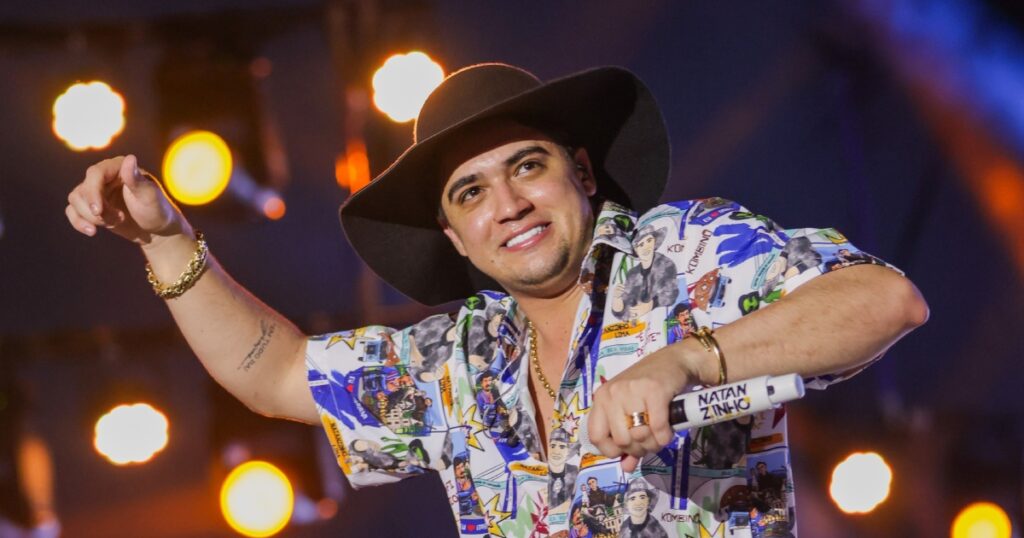 Natanzinho Lima realizando show gratuito em Paraisópolis, com o público animado ao redor.